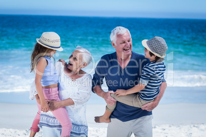 Happy grandparents giving piggy back to children