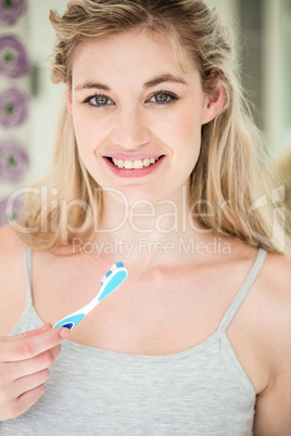 Portrait of happy woman brushing teeth