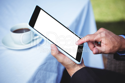 Businessman using tablet and having a coffee