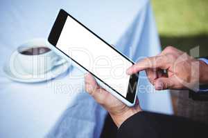 Businessman using tablet and having a coffee