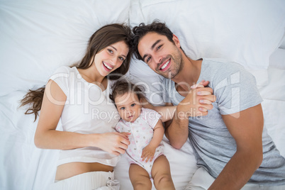 High angle view of happy family lying on bed High angle view of happy family lying on bed