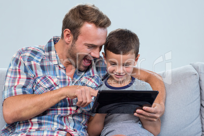 Father and son using digital tablet