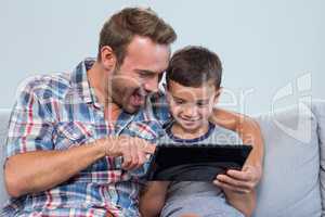 Father and son using digital tablet