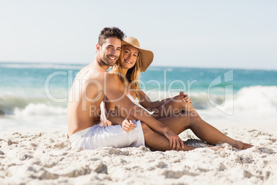 Young couple sitting on sand