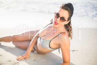 Glamorous woman in bikini lying on the beach