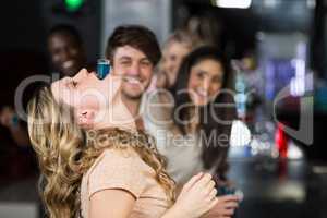 Blonde woman with a shot in her mouth