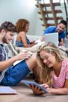 Young woman using digital tablet while friends in background