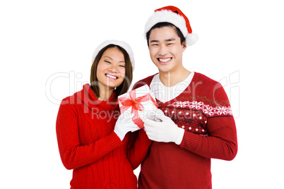 Young couple in christmas attire holding gift