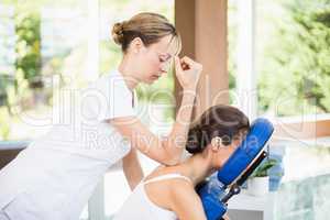 Side view of young woman receiving back massage
