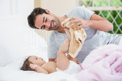 Smiling father with baby playing with napkin