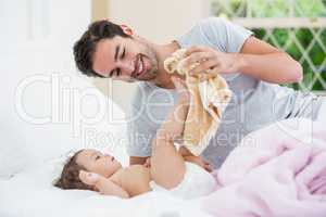 Smiling father with baby playing with napkin