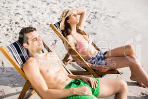 Young couple relaxing on armchair on the beach