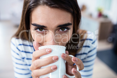 Young woman drinking coffee at home