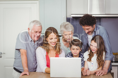 Family using laptop in kitchen