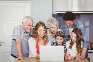 Family using laptop in kitchen