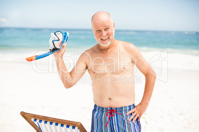 Senior man standing next to sunchair