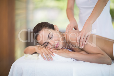 Woman enjoying massage from female masseur