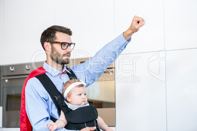 Father wearing superhero costume carrying daughter