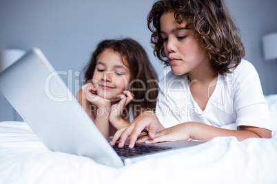 Brother and sister using digital tablet