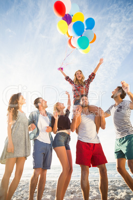 Friends posing with balloon on sand