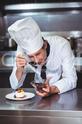 Chef putting chocolate sauce on a dessert