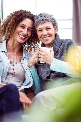 Portrait of happy mother and daughter with coffee mug