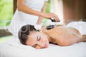 Young woman receiving stone massage
