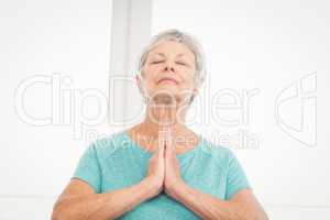 Senior woman praying at home