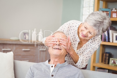 Senior woman hiding eyes of her husband