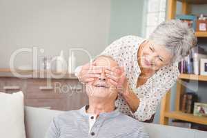 Senior woman hiding eyes of her husband