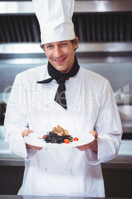 Chef holding a dish with spaghetti