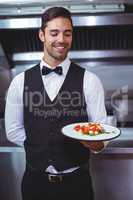 Handsome waiter holding a plate
