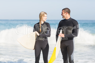 Couple with surfboard walking on the beach