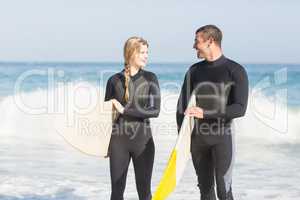 Couple with surfboard walking on the beach