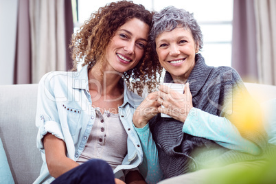 Portrait of smiling mother and daughter with coffee mug