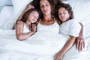 Children sleeping together with their mother