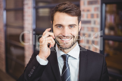 Portrait of happy businessman talking on cellphone