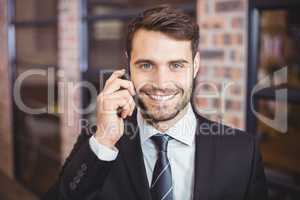 Portrait of happy businessman talking on cellphone