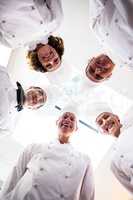Portrait of chefs team standing in a circle wearing uniforms