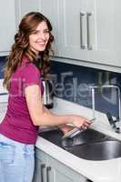 Happy woman washing plates