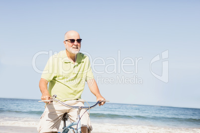 Smiling senior man riding bike