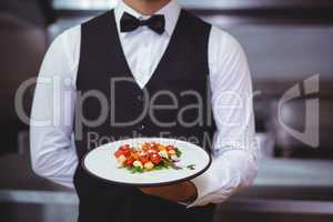 Handsome waiter holding a plate