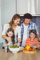 Happy family standing by table in kitchen