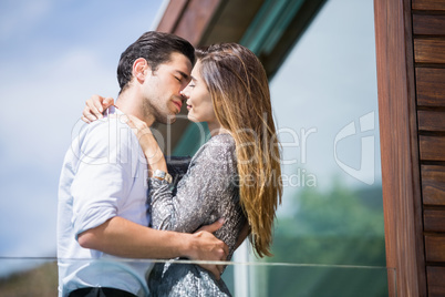 Romantic young couple kissing in balcony
