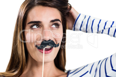 Smiling woman holding artificial mustache