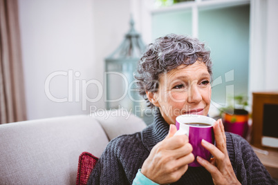 Thoughtful mature woman holding coffee cup