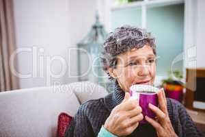 Thoughtful mature woman holding coffee cup