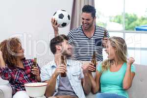 Friends enjoying beer while watching soccer match