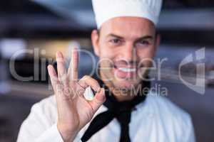 Happy chef making ok sign in commercial kitchen