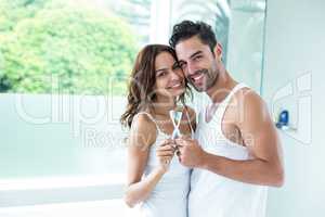 Portrait of couple embracing while holding toothbrush